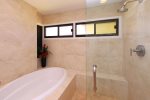 The large walk-in shower features bench seating